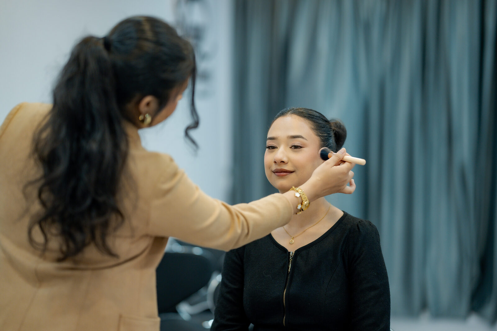 Shristi applying makeup to a client at the studio